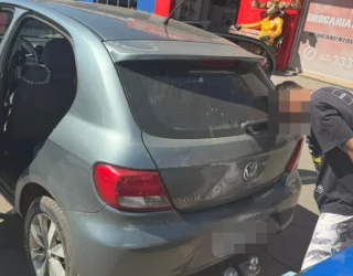 Imagem carro e homem preso de cabeça baixa