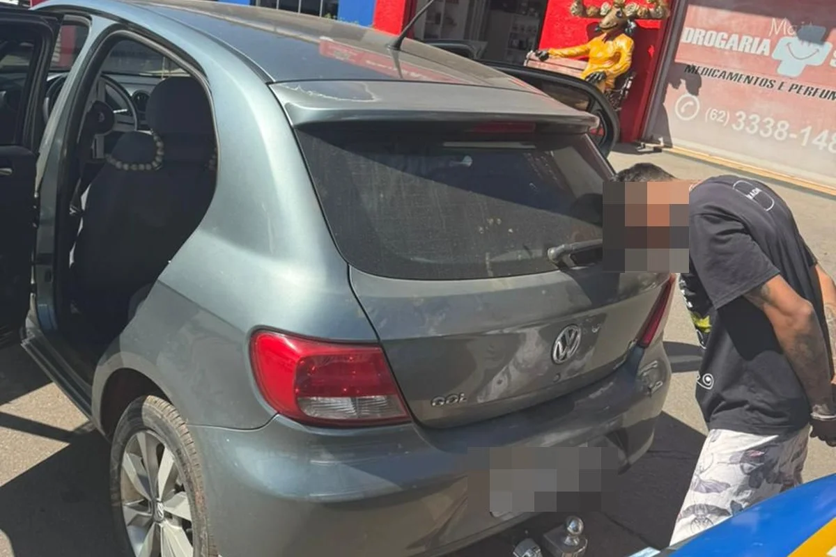 Imagem carro e homem preso de cabeça baixa