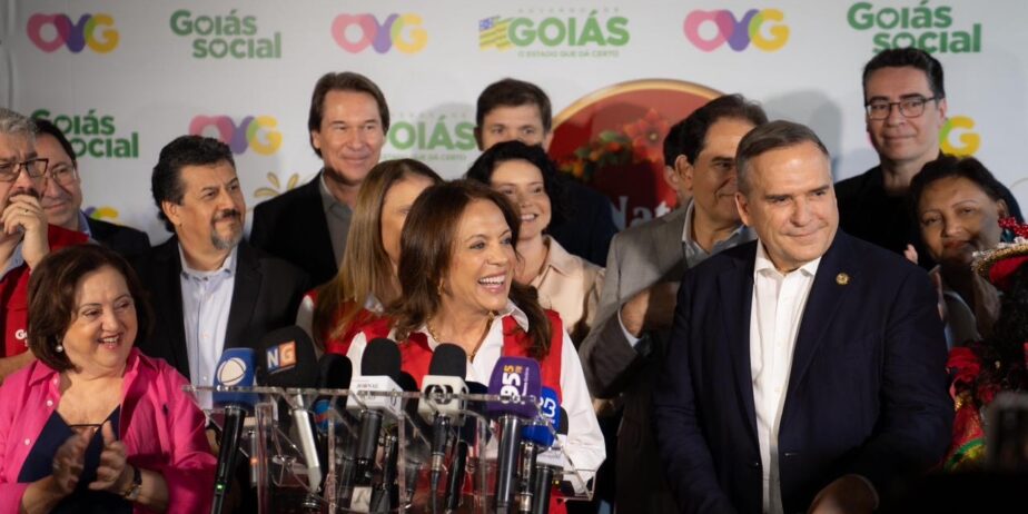 Imagem Gracinha Caiado entrevista coletiva, a frente varias microfones e pessoas ao lado e atrás