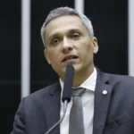 Imagem Gustavo Gayer, ele está de terno e falando no microfone