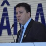 Imagem homem de terno falando ao microfone