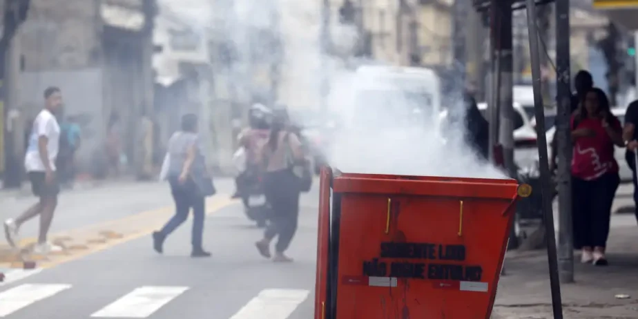 Imagem fumaça saindo da lata de lixo e pessoas correndo
