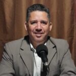 Imagem homem sorrindo em frente do microfone