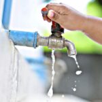 Imagem mão na torneira saindo pouca agua