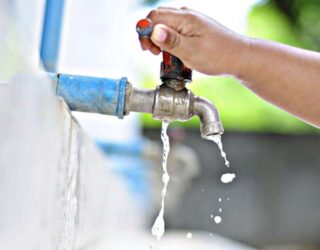 Imagem mão na torneira saindo pouca agua