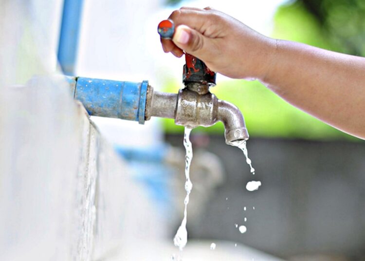 Imagem mão na torneira saindo pouca agua