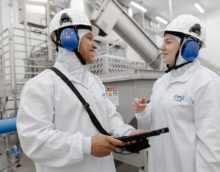 Imagem pessoas de roupas brancas e capacete com tapadores de ouvido cor azul