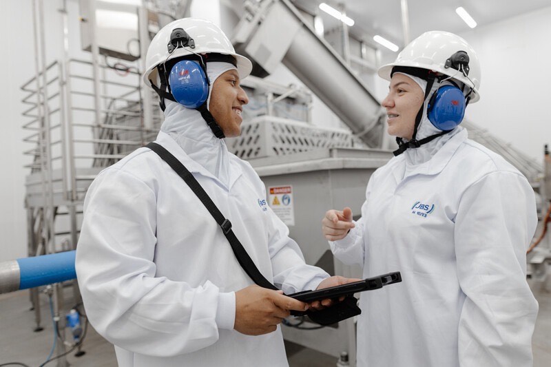Imagem pessoas de roupas brancas e capacete com tapadores de ouvido cor azul