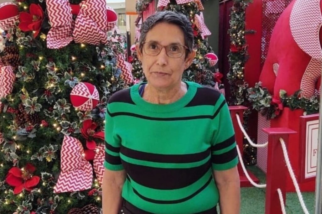 Imagem mulher de óculos e camisa verde listrada de preto