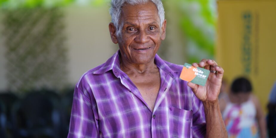 Imagem idoso sorrindo segurando um cartão