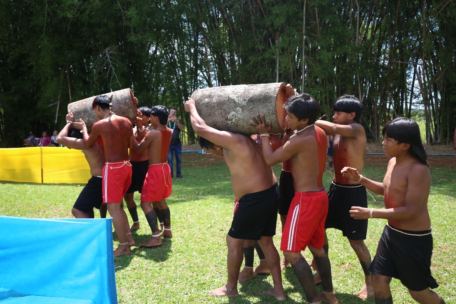 Imagens homens correndo com tora de madeira nos ombros