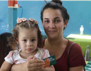 Imagem mulher segurando cartão e uma criança