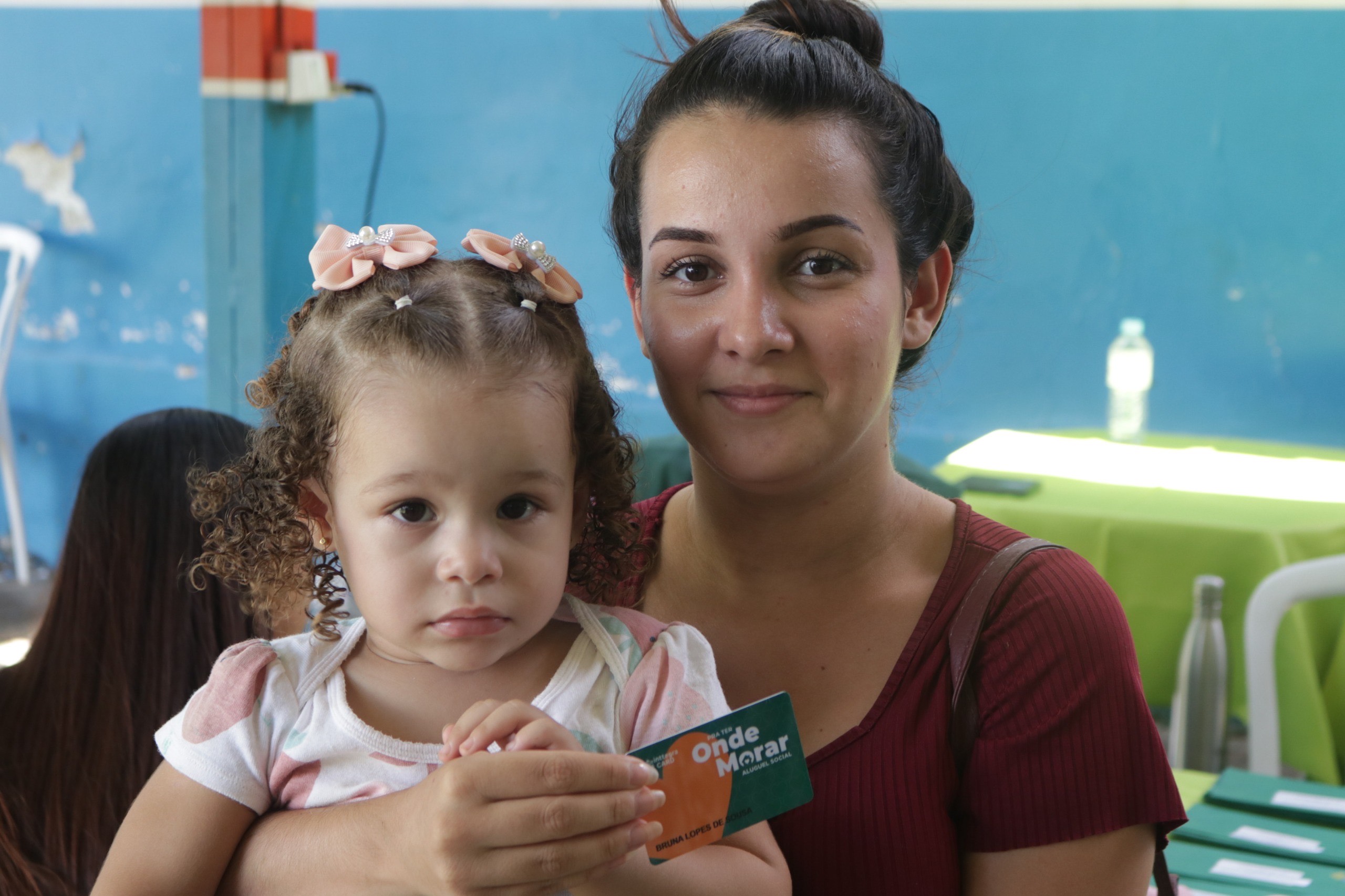 Imagem mulher segurando cartão e uma criança