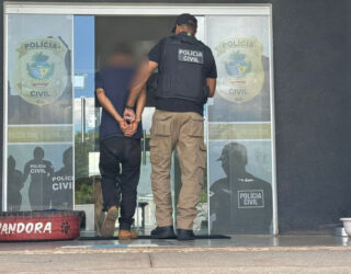 Imagem policial conduzindo homem algemado