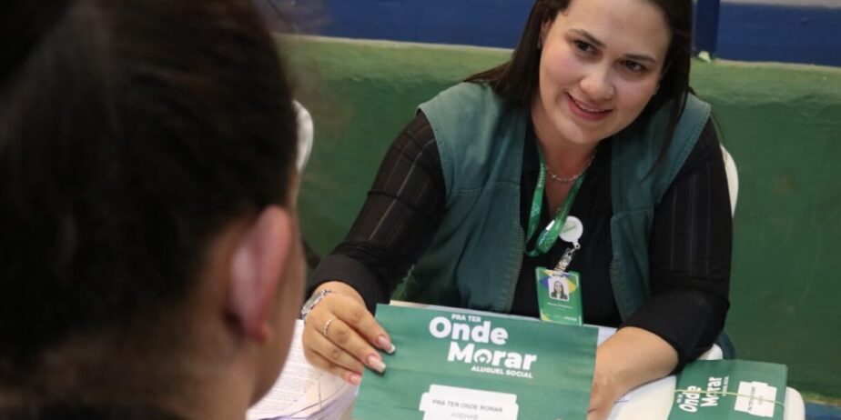 Imagem mulher atendendo mostrando papel para outra pessoa na mesa