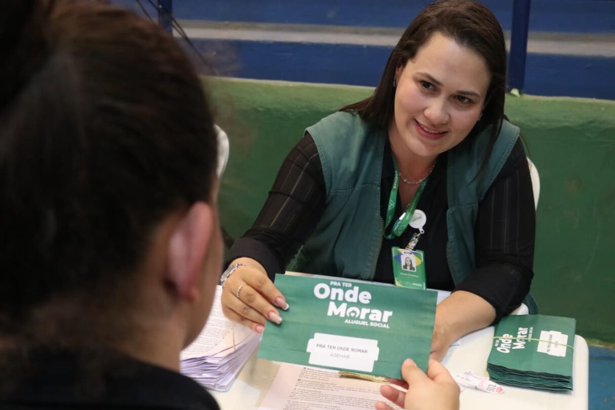 Imagem mulher atendendo mostrando papel para outra pessoa na mesa