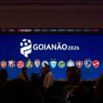 Imagem escura pessoas a frente de um telão