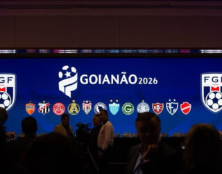 Imagem escura pessoas a frente de um telão