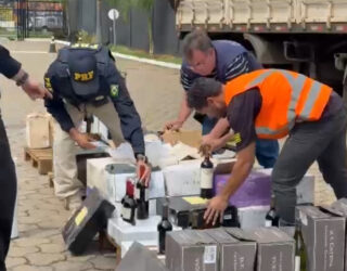 Imagem policiais e agentes fiscalizando mercadoria de vinho