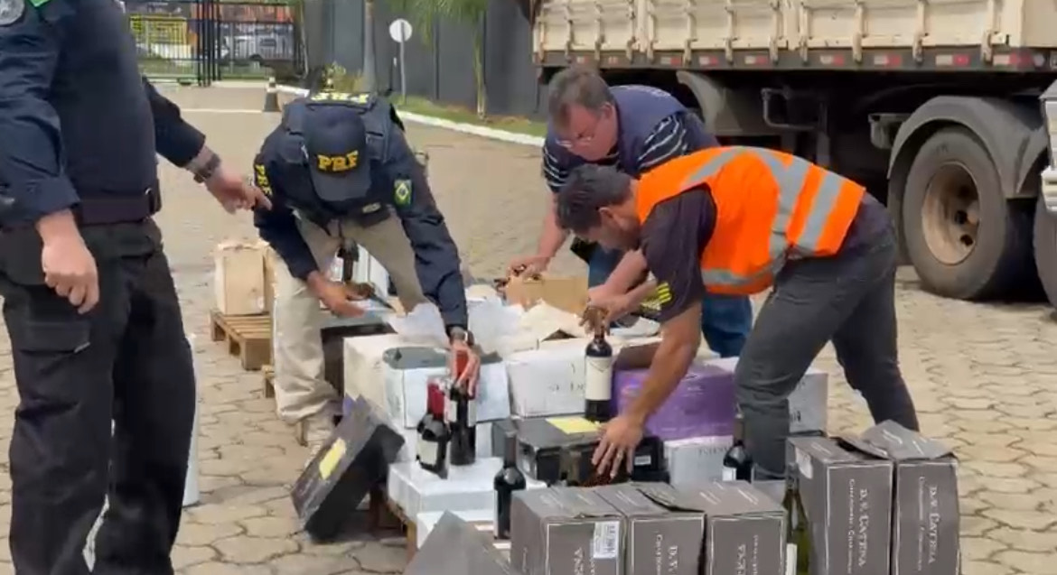 Imagem policiais e agentes fiscalizando mercadoria de vinho
