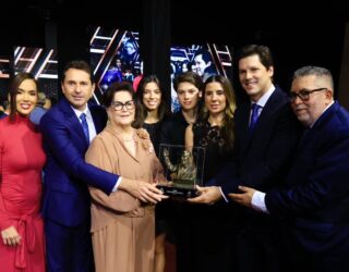 Imagem pessoas segurando troféu e sorrindo para foto