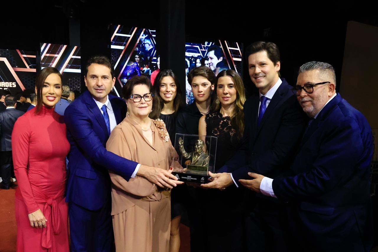 Imagem pessoas segurando troféu e sorrindo para foto