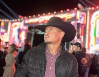 Imagem homem de chapéu e jaqueta preta olhando para o lado