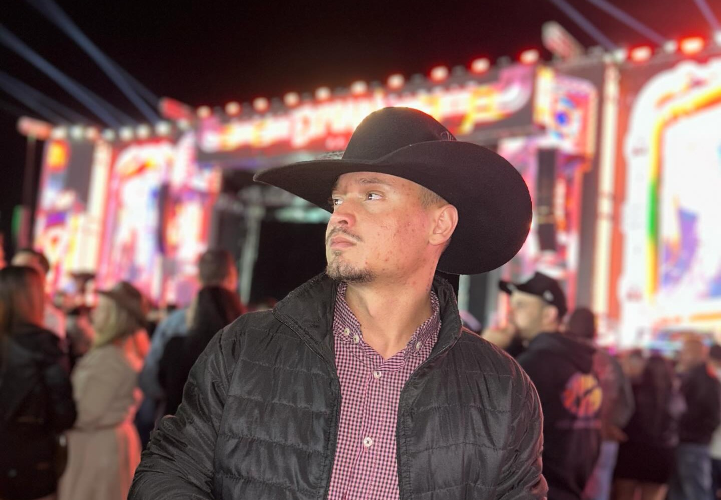 Imagem homem de chapéu e jaqueta preta olhando para o lado