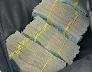 Imagem dinheiro em espécie enrolado em liga amarela