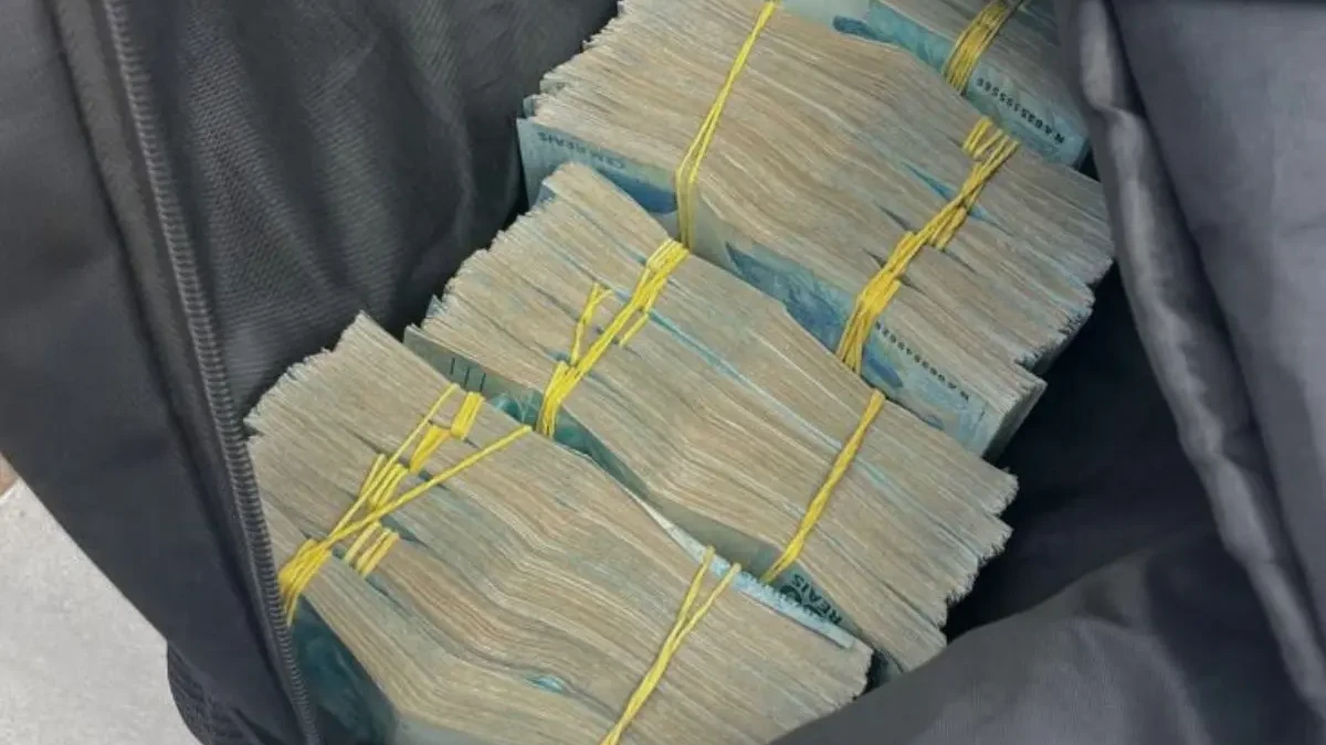 Imagem dinheiro em espécie enrolado em liga amarela