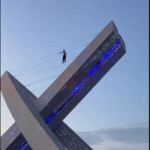 Imagem homem caminhando sobre cabos de viaduto