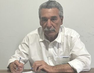 Imagem homem de bigode e camiseta branca segurando caneta