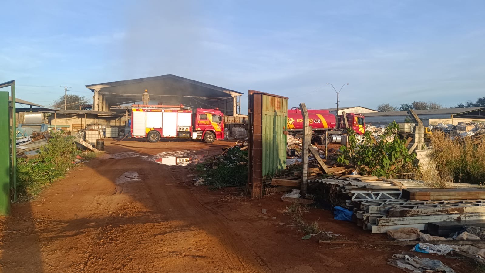 Imagem área com terreno grande e um caminhão dos bombeiros no fundo