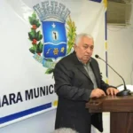 Imagem homem terno preto falando ao microfone