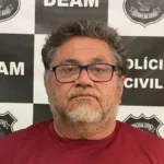 Imagem homem de óculos e barba branca, camisa vermelha ao fundo identificação da policia civil