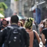 Imagem pessoas de costas andando pela rua