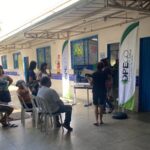 Imagem pessoas em pé e outras sentadas aguardando atendimento