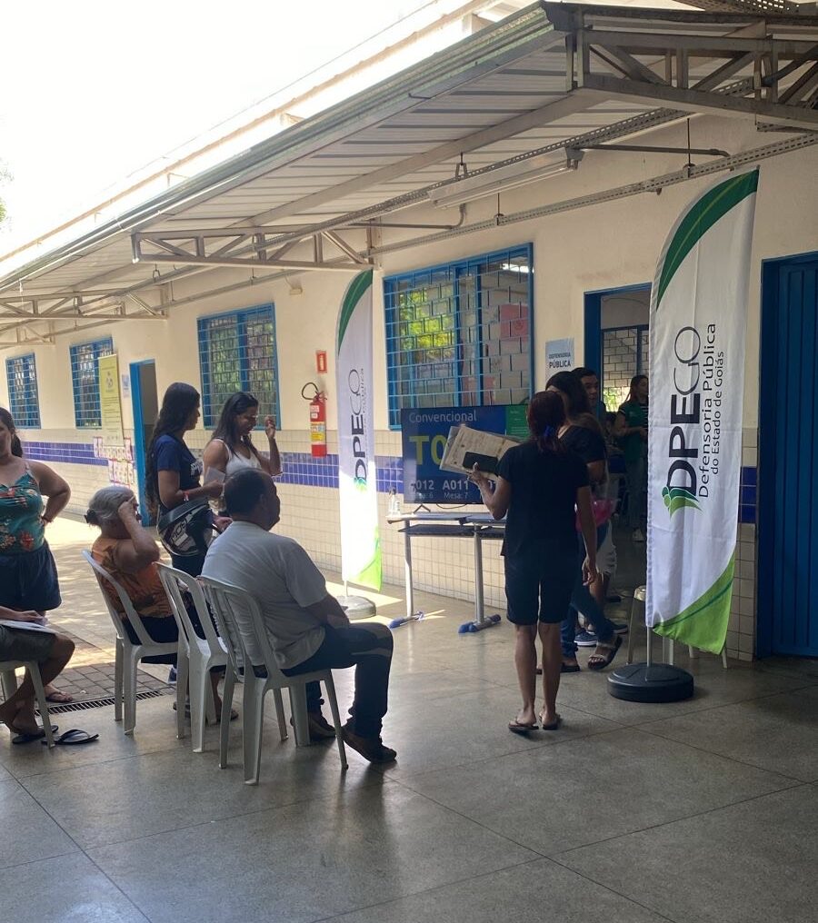 Imagem pessoas em pé e outras sentadas aguardando atendimento