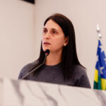 Imagem mulher cabelos longos falando ao microfone