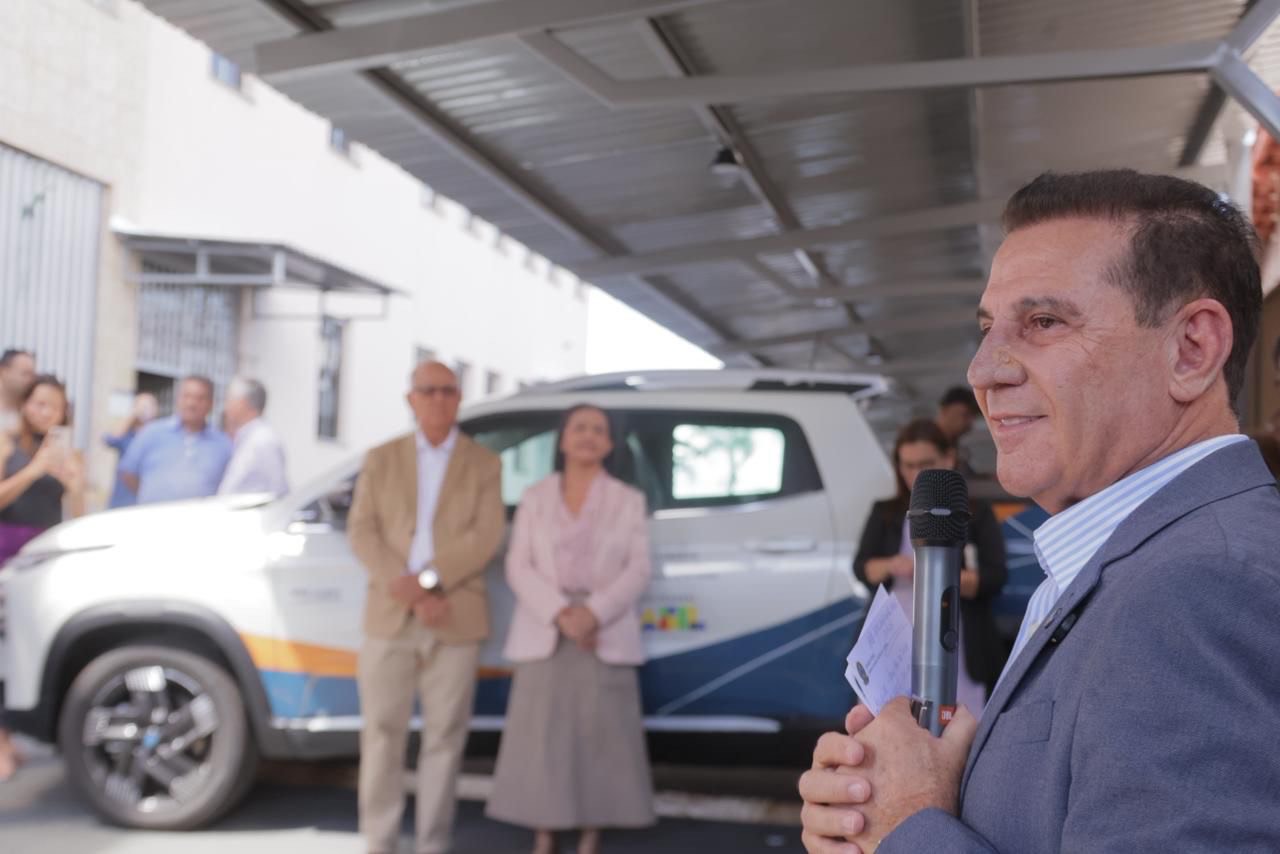 Imagem homem falando ao fundo pessoas em pé