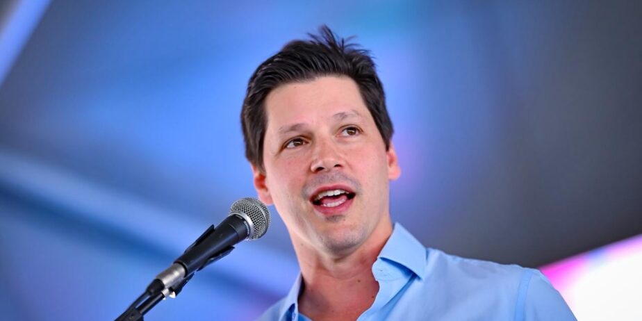 Imagem homem camisa azul falando ao microfone