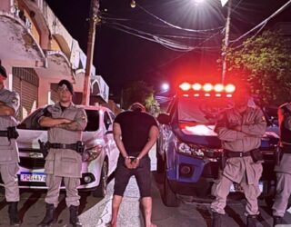 Imagem homem de costas preso ao lado policiais militares