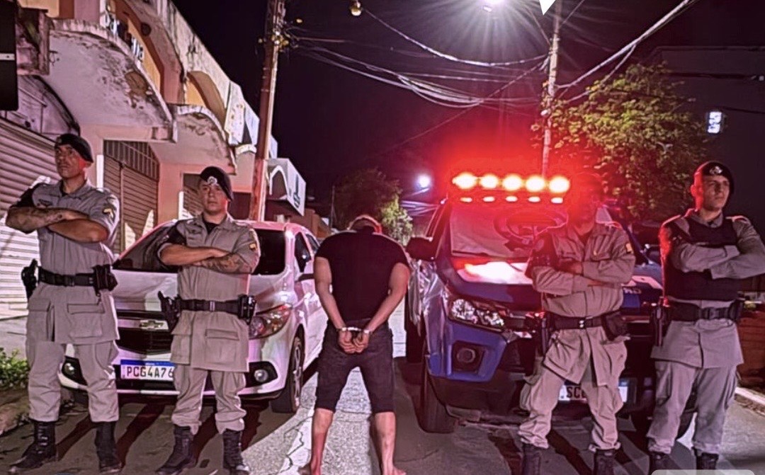 Imagem homem de costas preso ao lado policiais militares