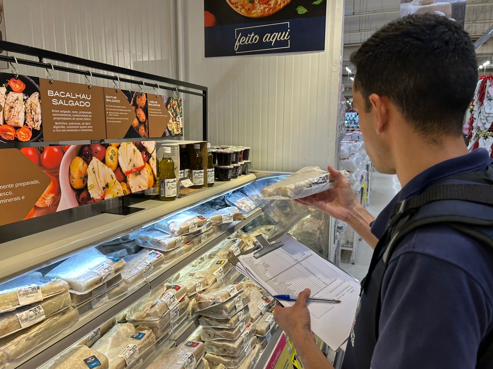 Imagem homem segurando folha de anotação em supermercado