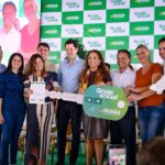 Imagem pessoas sorrindo segurando grande chave simbolica