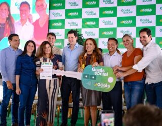 Imagem pessoas sorrindo segurando grande chave simbolica