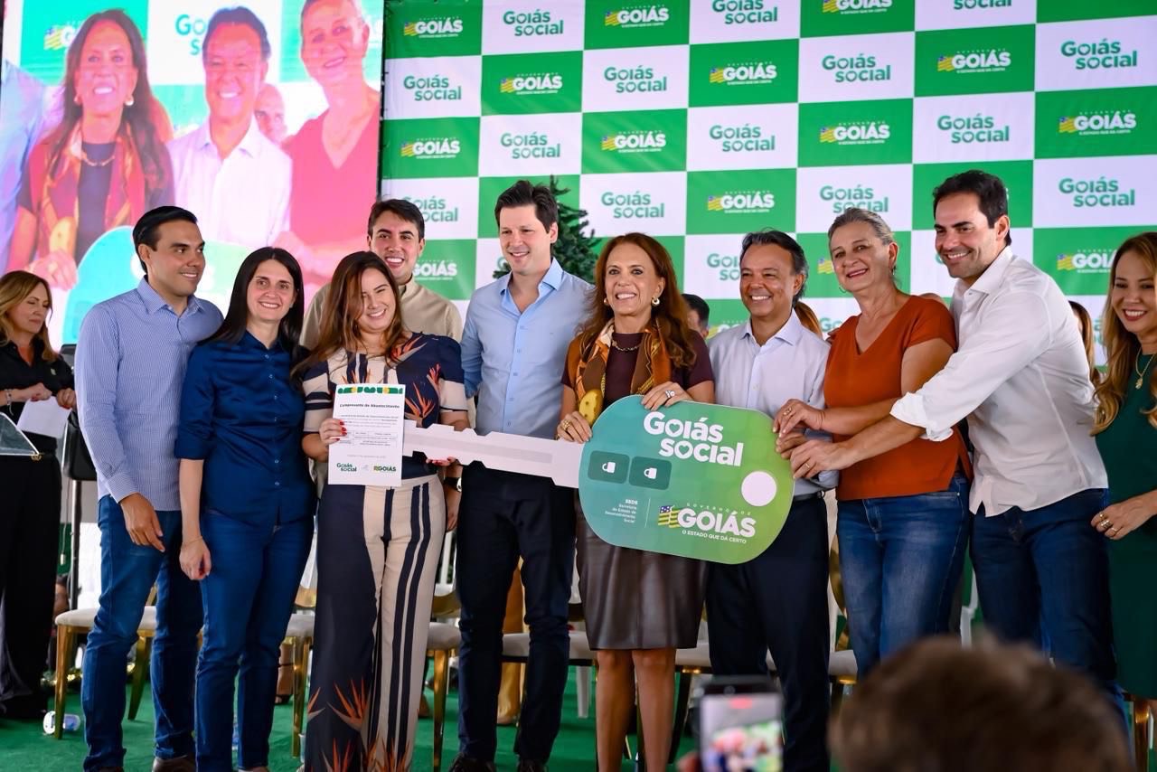 Imagem pessoas sorrindo segurando grande chave simbolica