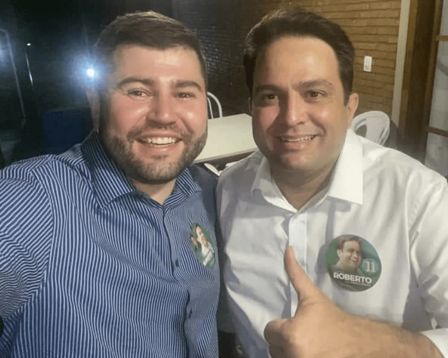 Imagem dois homens sorrindo e abraçados