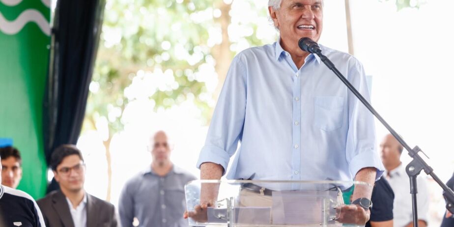 Imagem homem de camisa azul falando ao microfone