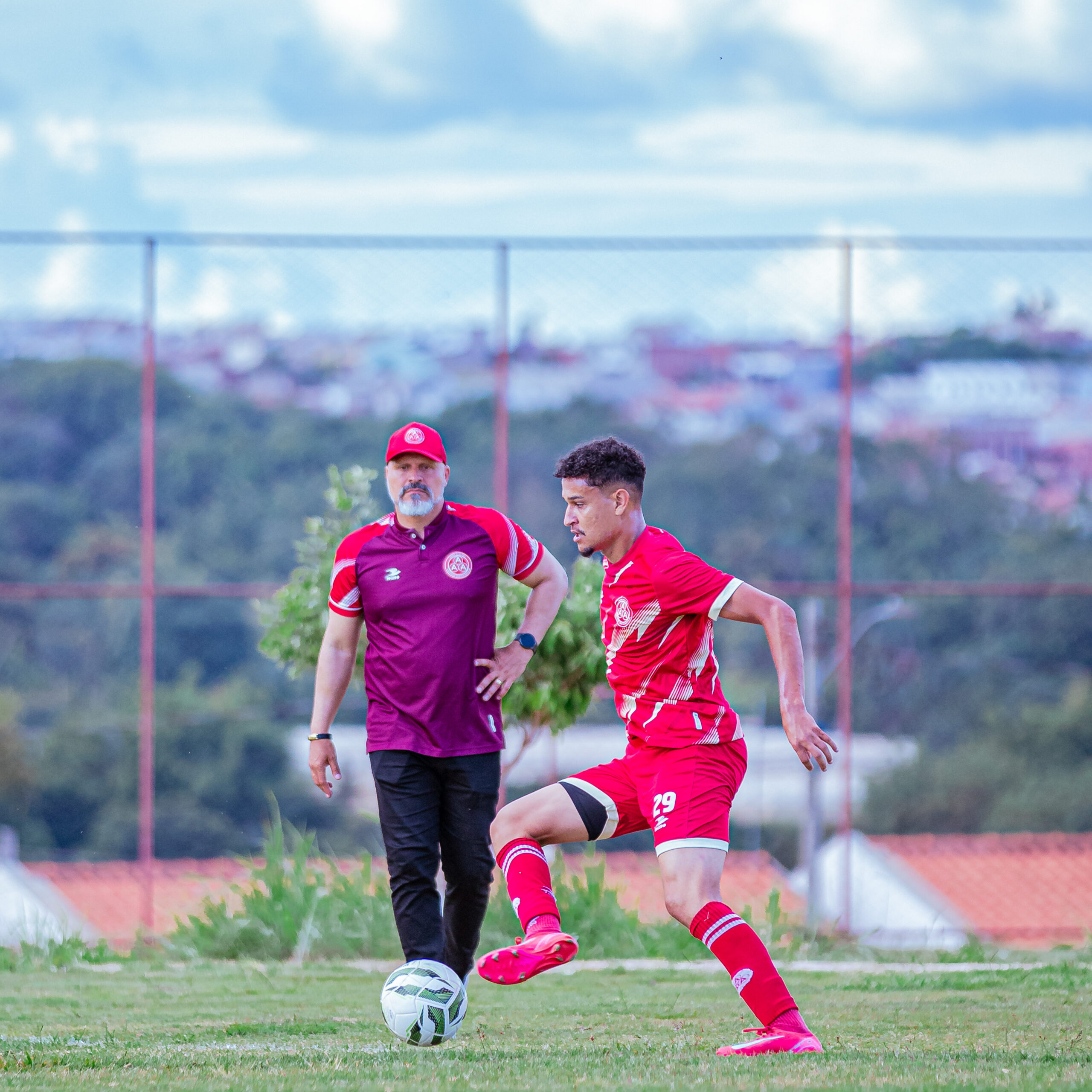 Imagem jogador de futebol ao fundo o treinador